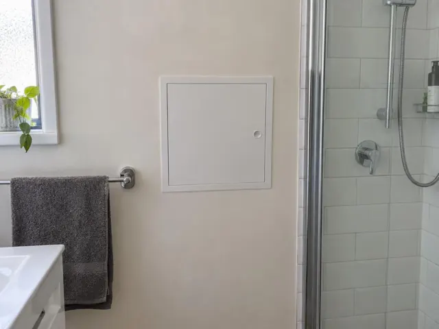Neat wall access panel beside a tiled shower in a bathroom in Gordon